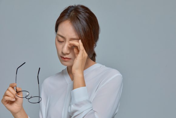 안경을 벗고 눈 통증을 호소하는 여성