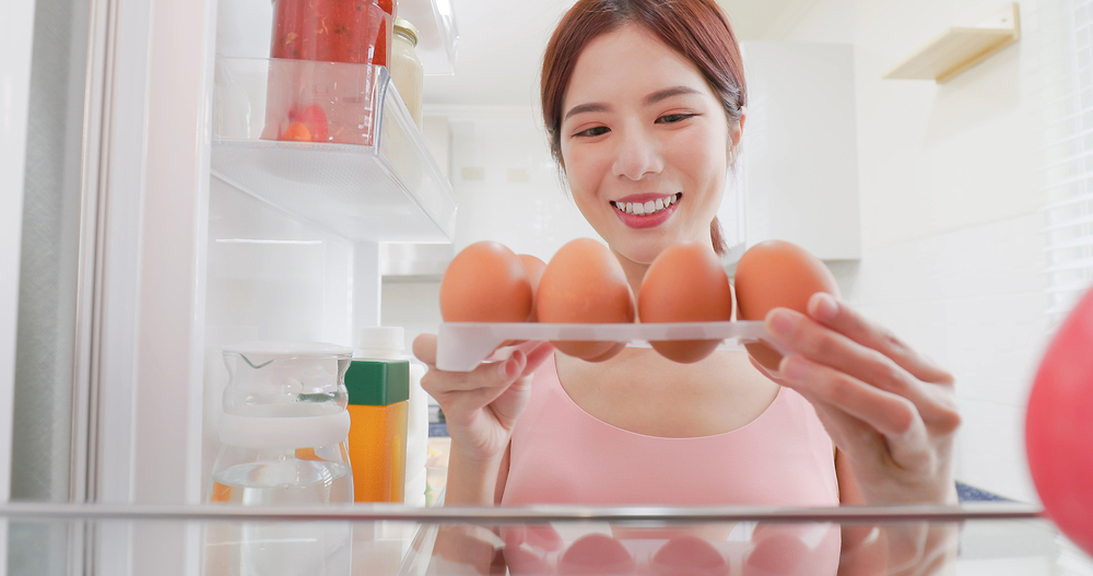 냉장고 속 달걀을 점검해보고 있는 여성